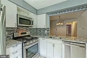 a kitchen with stainless steel appliances granite countertop a stove and a microwave