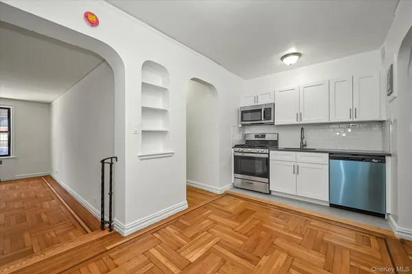 a kitchen with granite countertop a refrigerator and a stove top oven