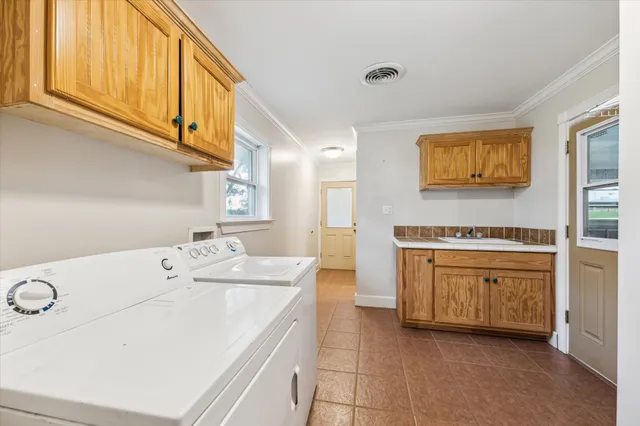 a utility room with cabinets washer and dryer