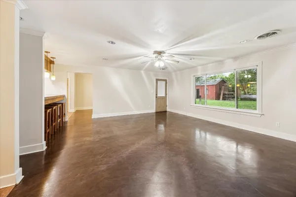 a view of a livingroom with a ceiling fan window and wooden floor