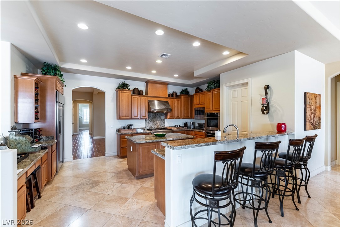 3661 Riley Ann Avenue Las Vegas, NV 89139 - Photo 12 of 42 A well-appointed kitchen features rich wood cabinetry, granite countertops, and modern stainless steel appliances.
