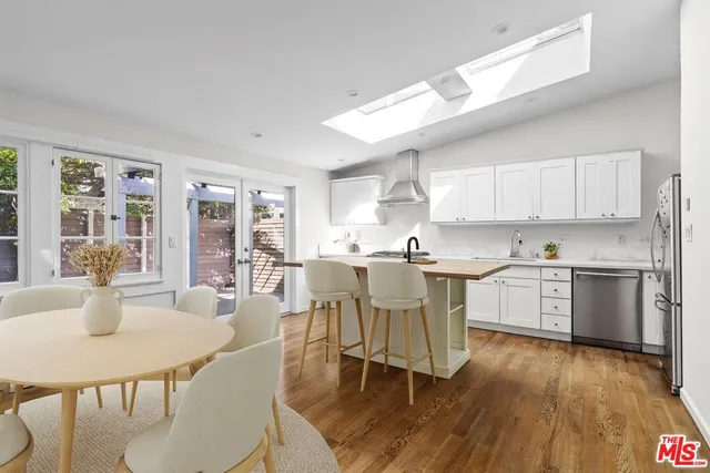 a kitchen with a dining table chairs and white cabinets