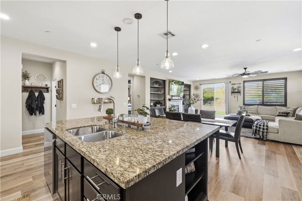 24903 Shadow Ridge Court Valencia, CA 91354 - Photo 12 of 43 a kitchen with granite countertop a table chairs and flat screen tv