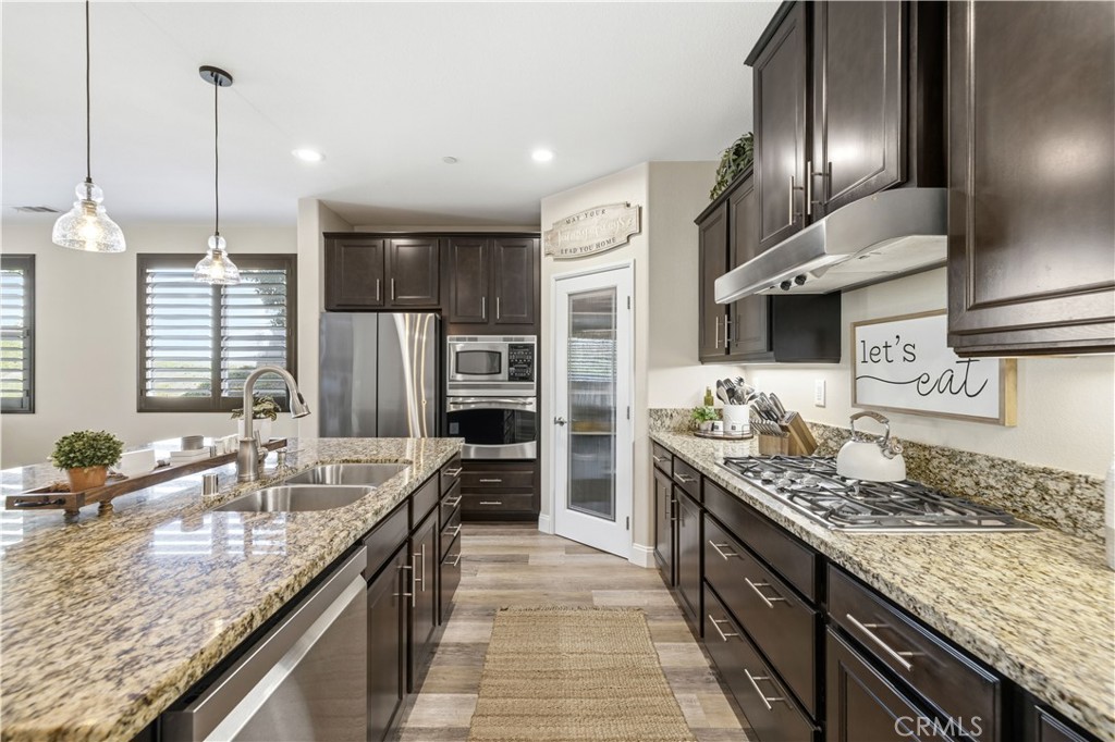 24903 Shadow Ridge Court Valencia, CA 91354 - Photo 10 of 43 a kitchen with stainless steel appliances granite countertop a sink stove and refrigerator