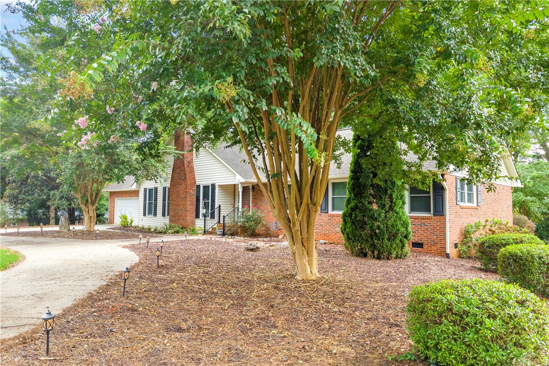 103 Colleton Court Clemson, SC 29631 - Photo 43 of 49 Mature trees frame a classic brick and siding exterior with a curved driveway.