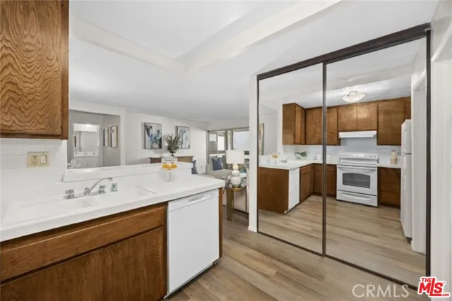 a view of kitchen with sink refrigerator and cabinets