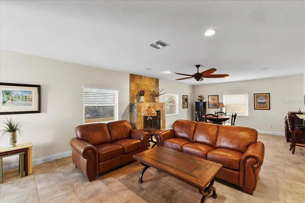 a living room with furniture a ceiling fan and a window