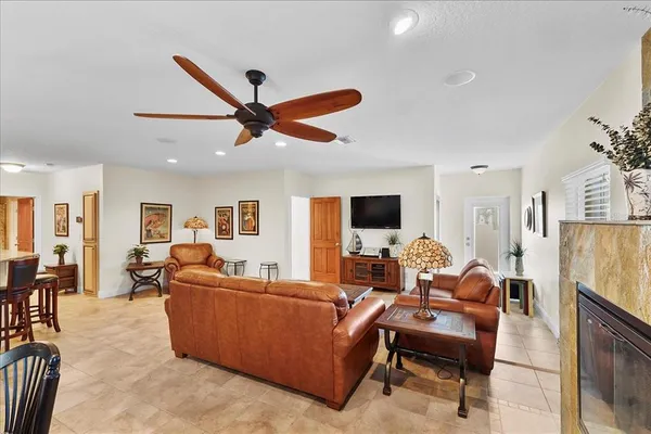 a living room with furniture a flat screen tv and kitchen view