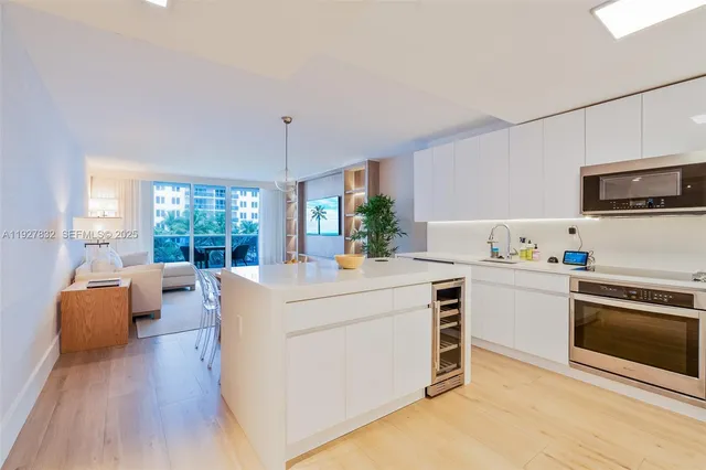 a kitchen with kitchen island wooden floors and stainless steel appliances