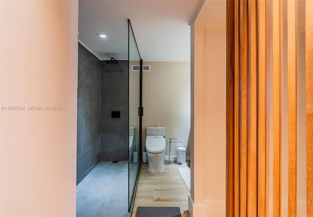 a bathroom with a granite countertop sink a toilet and shower