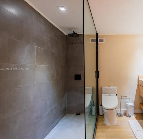 a bathroom with a toilet and a shower