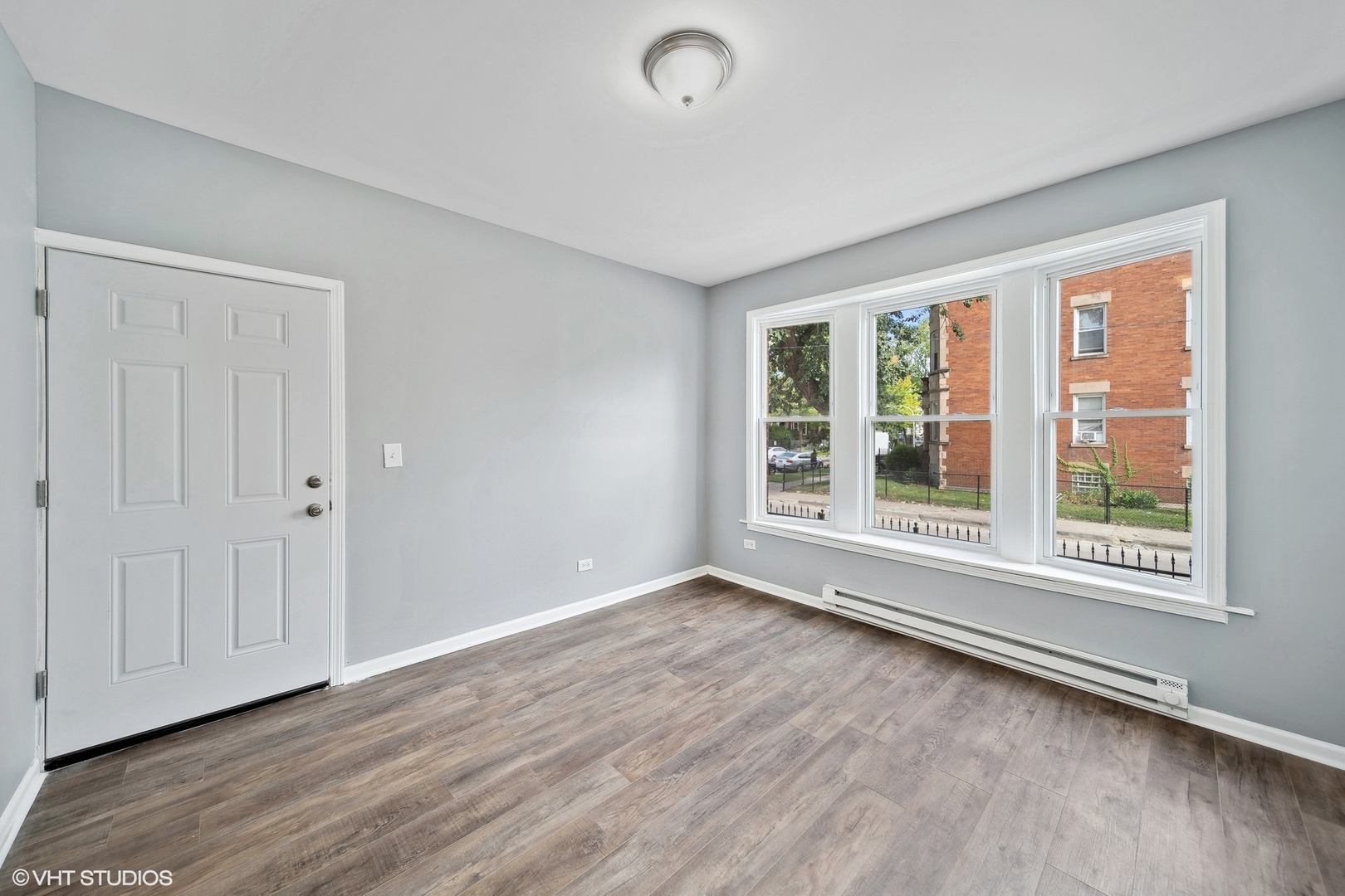 6601 South Green Street, Unit 2 Chicago, IL 60621 - Photo 2 of 11 a view of an empty room with wooden floor and a window