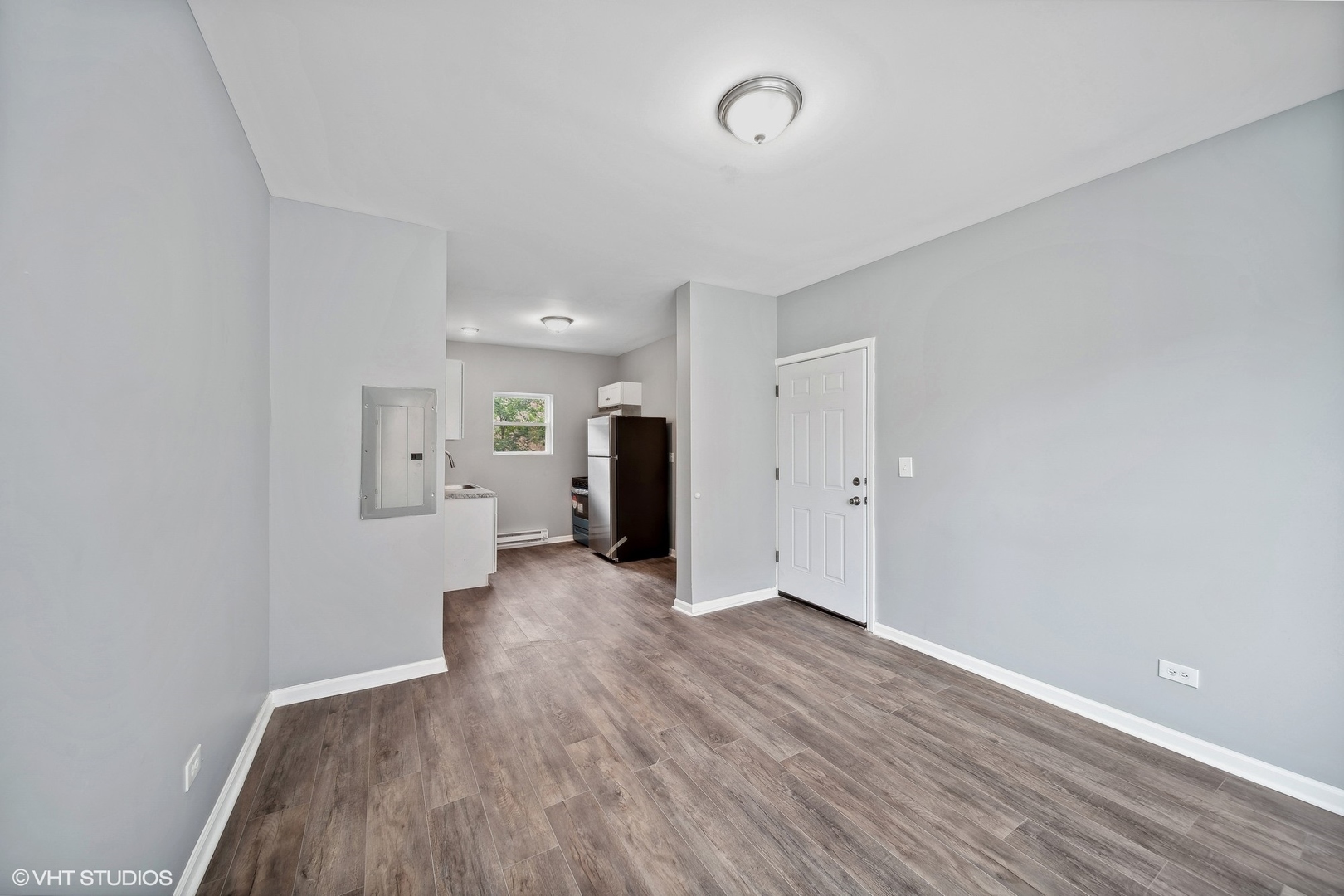 6601 South Green Street, Unit 2 Chicago, IL 60621 - Photo 4 of 11 a view of a big room with wooden floor and a kitchen