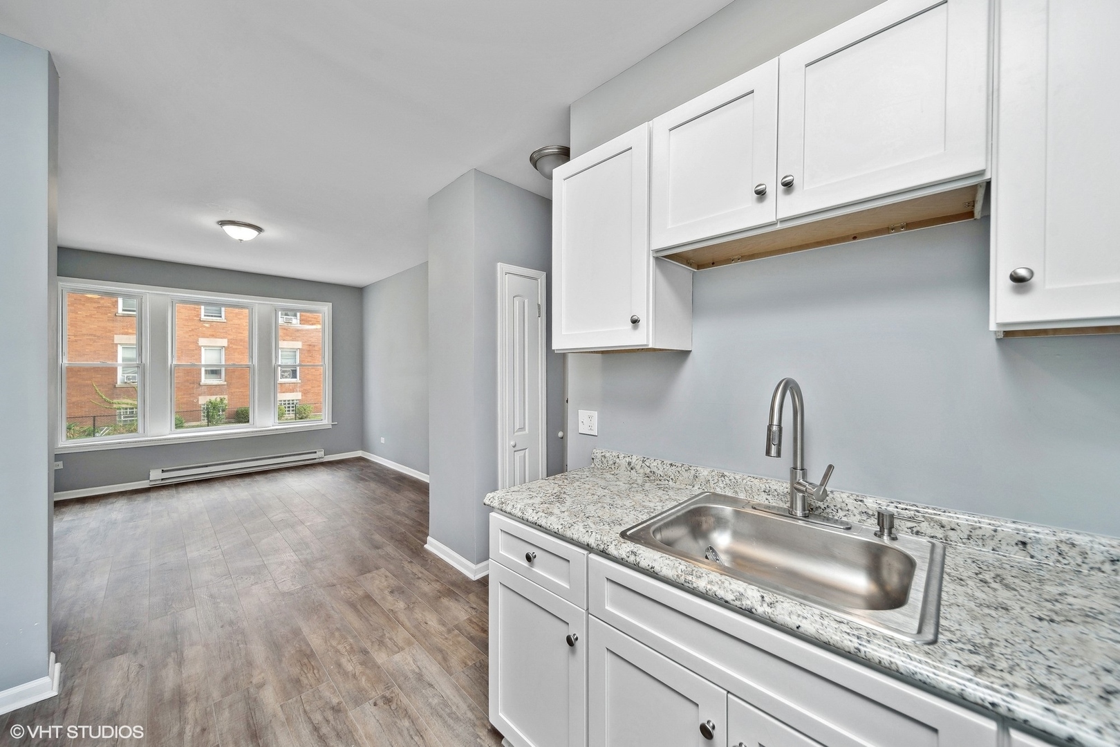 6601 South Green Street, Unit 2 Chicago, IL 60621 - Photo 6 of 11 a kitchen with a sink cabinets and a wooden floor