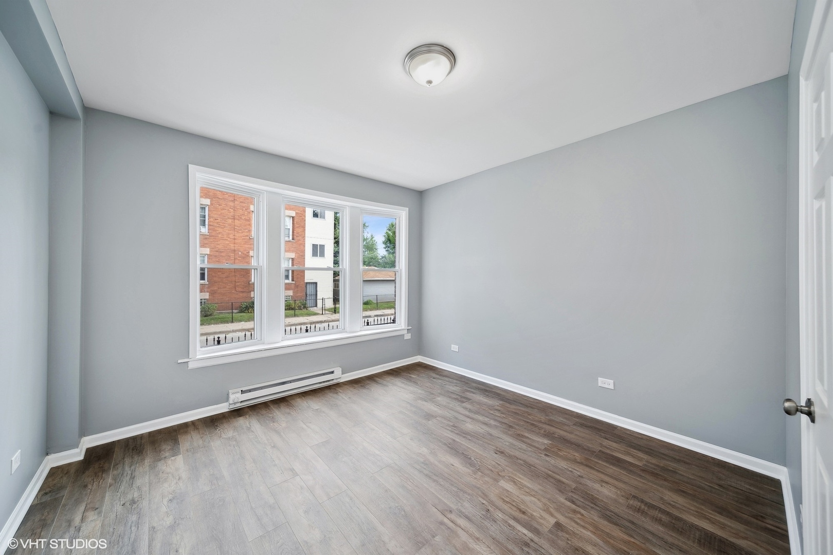 6601 South Green Street, Unit 2 Chicago, IL 60621 - Photo 8 of 11 an empty room with wooden floor and windows