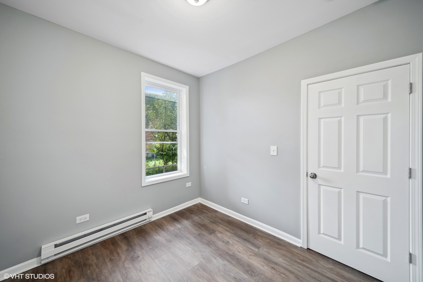 6601 South Green Street, Unit 2 Chicago, IL 60621 - Photo 10 of 11 an empty room with wooden floor and a window