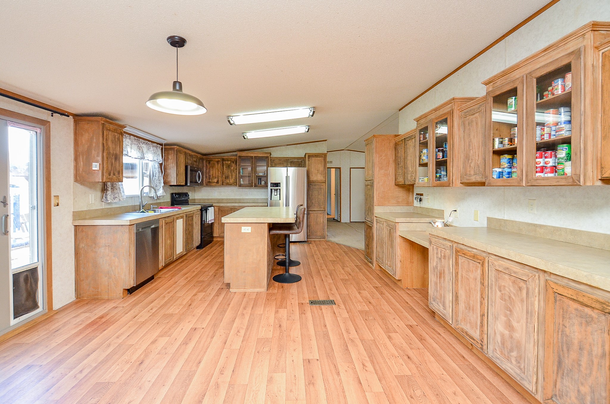 5440 7th Street Sheridan, TX 77475 - Photo 12 of 37 a large kitchen with stainless steel appliances granite countertop a lot of counter space and wooden floors