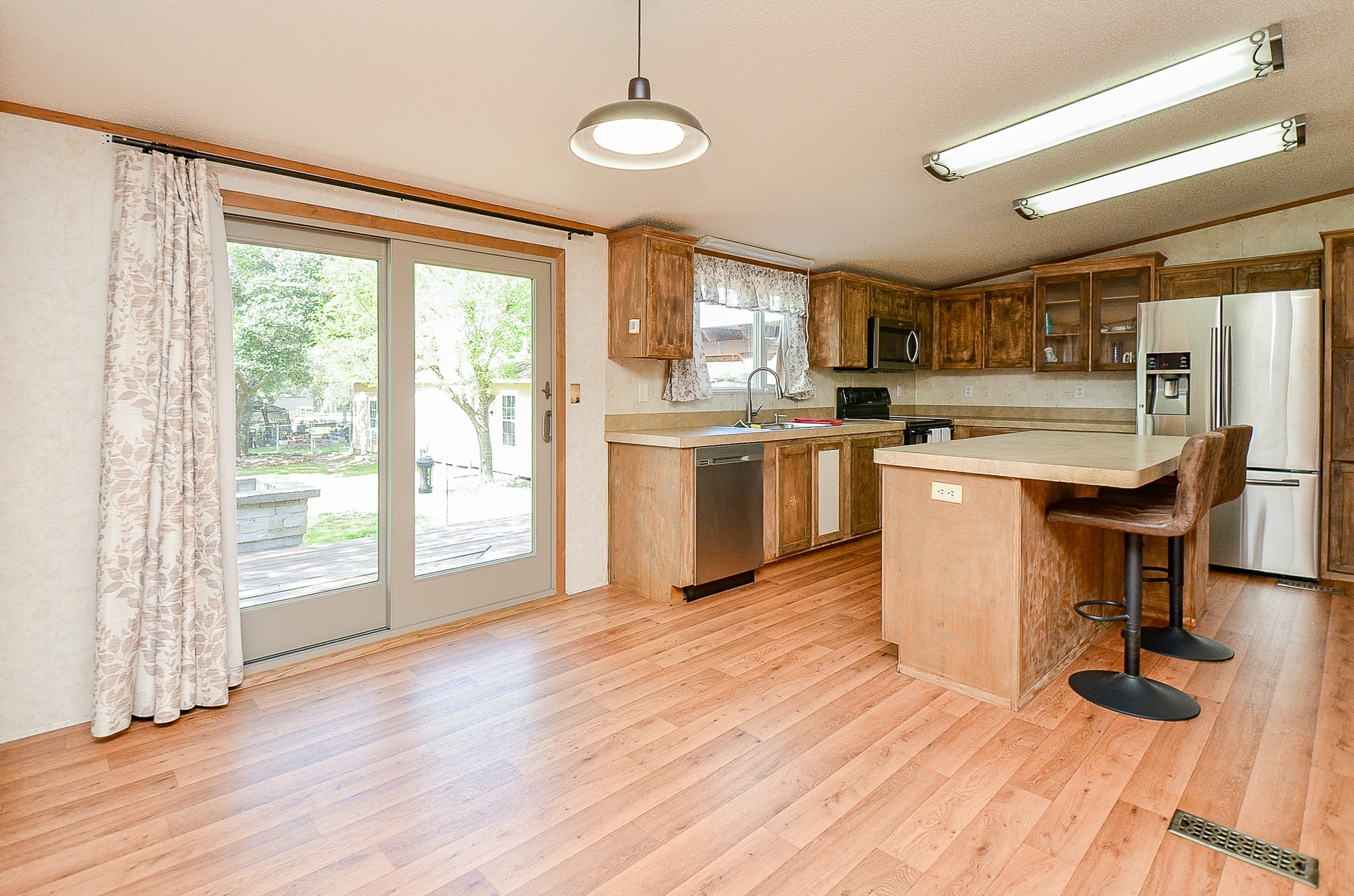 5440 7th Street Sheridan, TX 77475 - Photo 26 of 37 a kitchen with stainless steel appliances granite countertop a stove and a wooden floors
