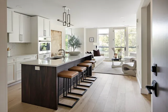 a living room with furniture a large window a table and chairs