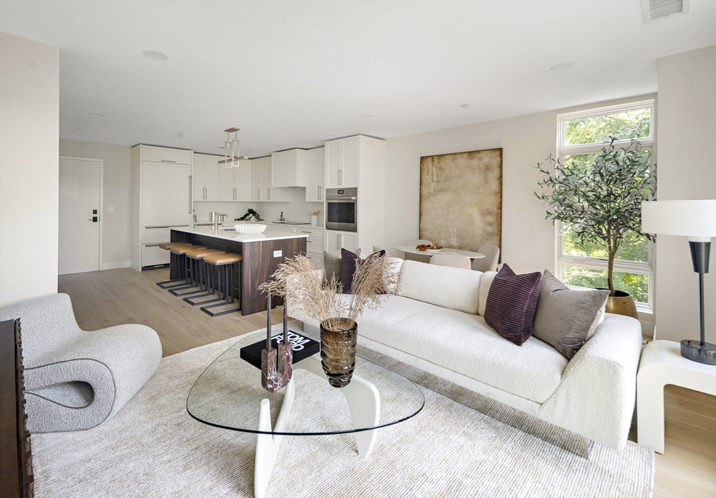 20 Kinmonth Road, Unit 201 Newton, MA 02468 - Photo 5 of 12 a living room with furniture a fireplace and a table