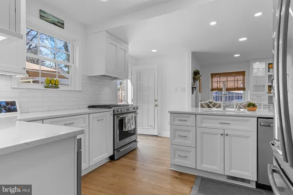 a kitchen with white cabinets and stainless steel appliances
