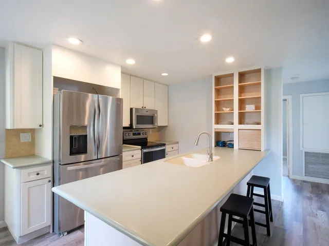 a kitchen with stainless steel appliances granite countertop a sink and a refrigerator