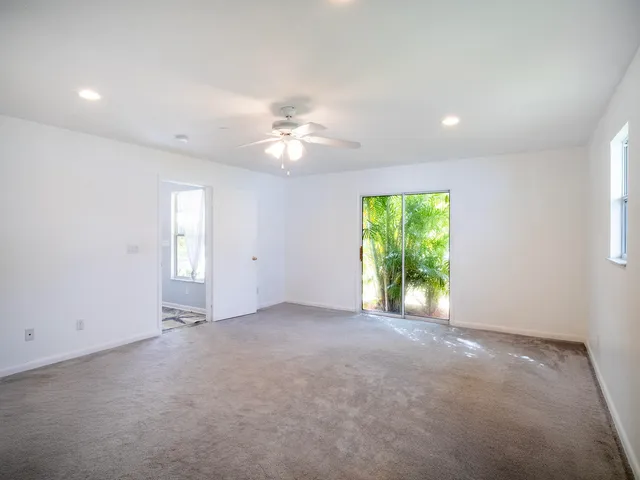 an empty room with closet and a ceiling fan