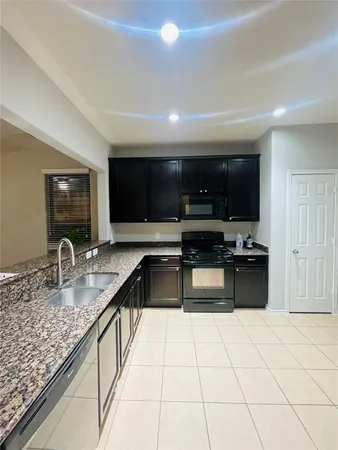 a kitchen with stainless steel appliances granite countertop a sink and a stove