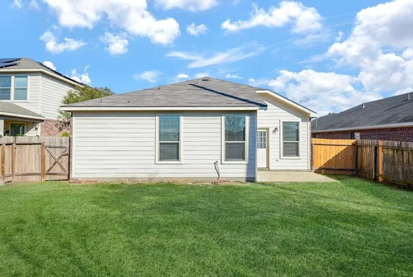 a house that has a big yard with wooden fence