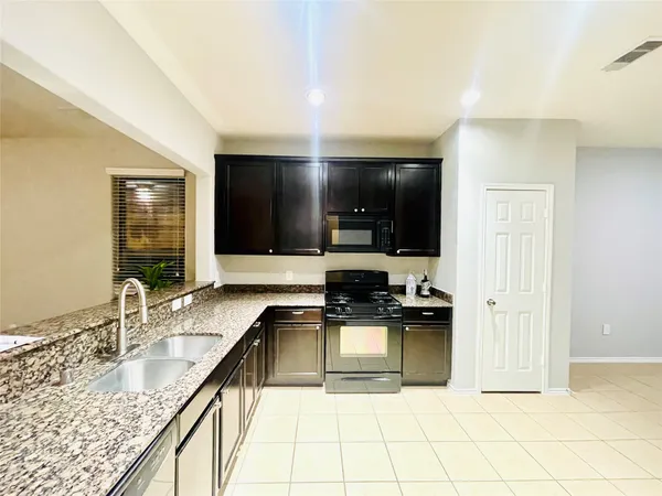 a kitchen with granite countertop a sink and a stove top oven