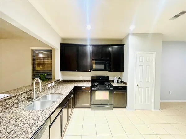 a kitchen with granite countertop a sink and a stove top oven