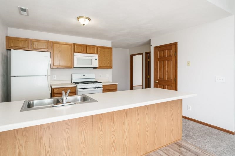 10135 Monarch Road, Unit 4 120D Roscoe, IL 61073 - Photo 13 of 26 a kitchen with a sink a stove and a refrigerator