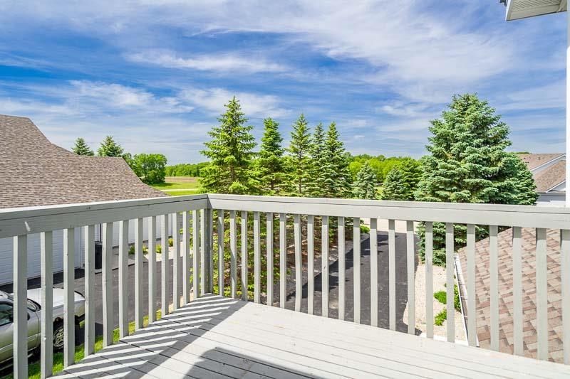 10135 Monarch Road, Unit 4 120D Roscoe, IL 61073 - Photo 5 of 26 a balcony with wooden floor and fence