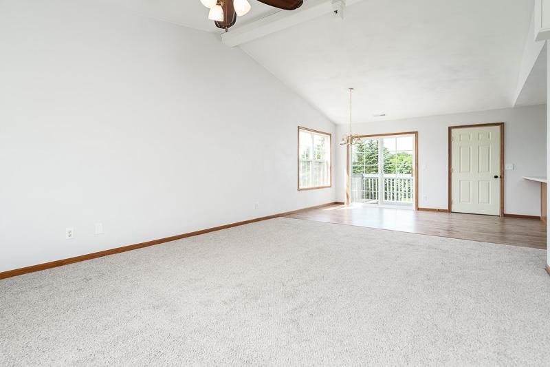 10135 Monarch Road, Unit 4 120D Roscoe, IL 61073 - Photo 10 of 26 an empty room with windows and chandelier fan