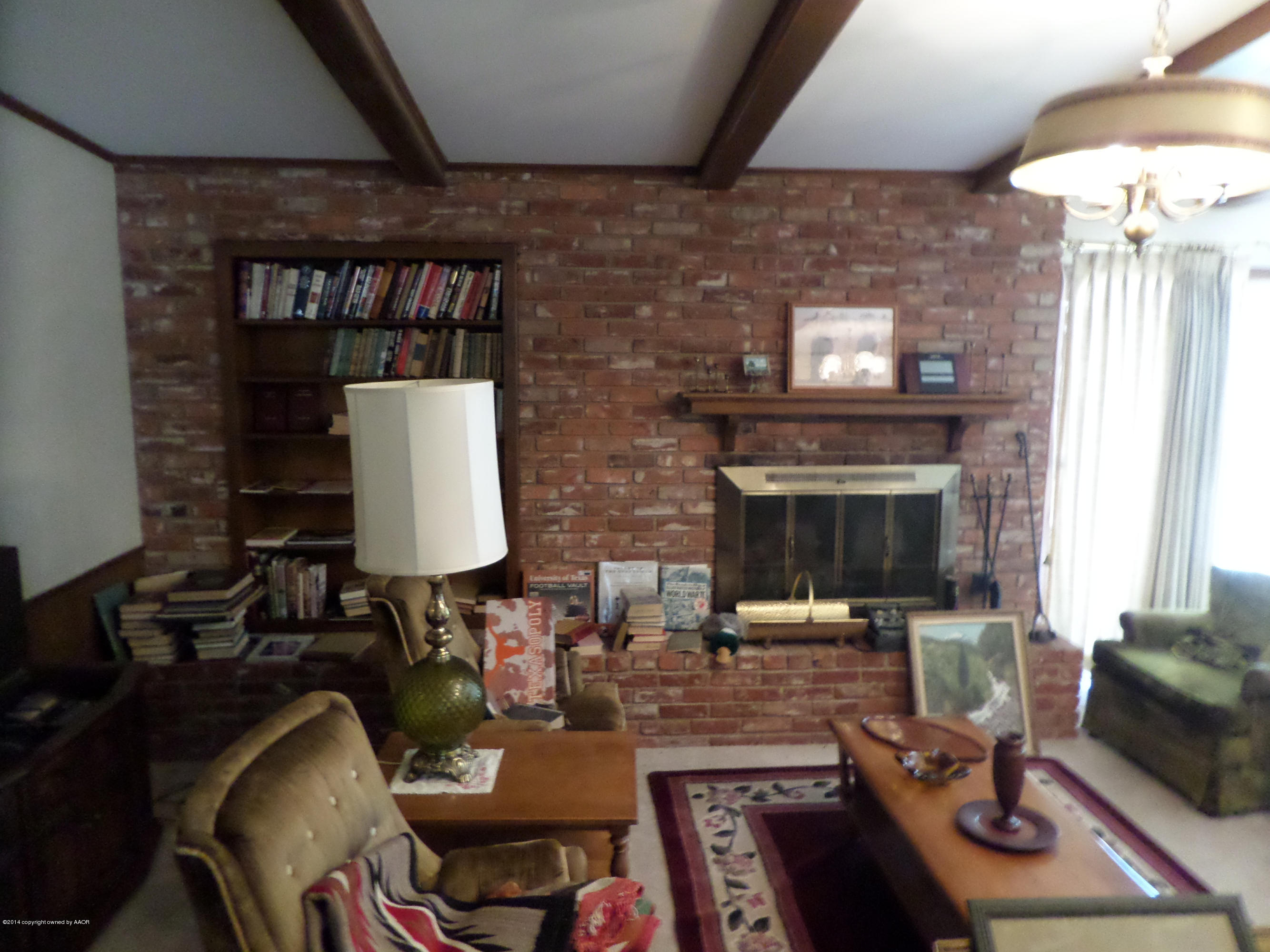 6911 Calumet Road Amarillo, TX 79106 - Photo 2 of 8 a living room with furniture a fireplace and a table