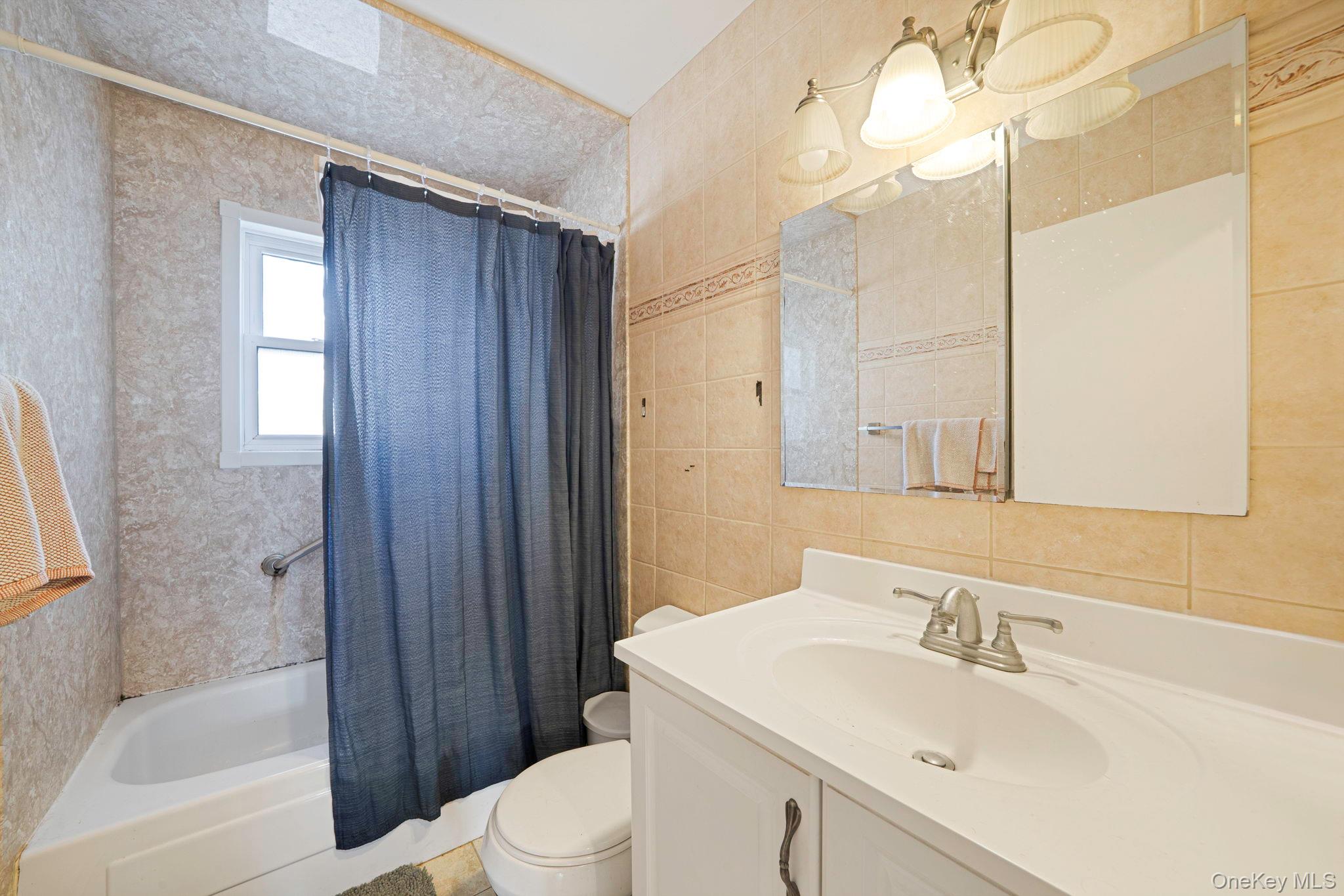 39 Kay Road Calverton, NY 11933 - Photo 14 of 17 Full bathroom featuring shower / bath combo with shower curtain, vanity, and tile walls