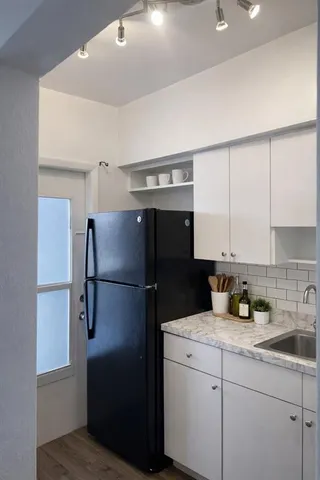 a kitchen with a refrigerator a sink and cabinets