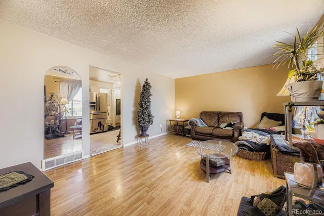 a living room with furniture and a wooden floor