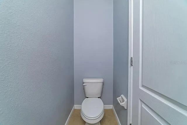 a white toilet sitting next to a white wall