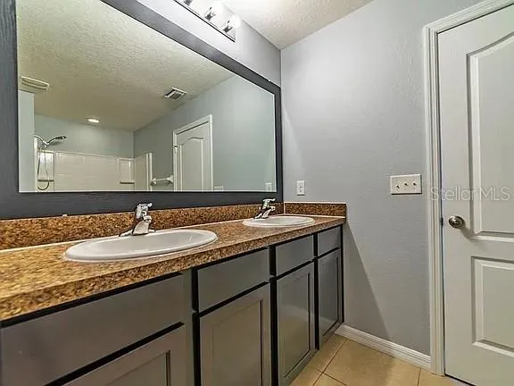 a bathroom with a granite countertop sink and a mirror
