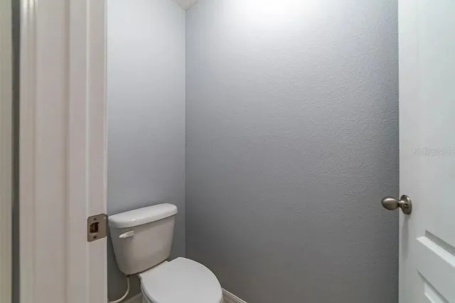 a white toilet sitting next to a shower