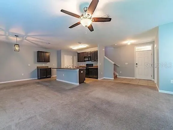 a view of an empty room with a kitchen