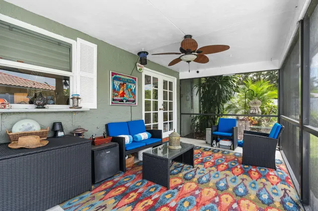 a living room with patio furniture and a floor to ceiling window