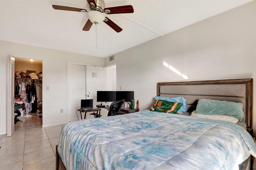 5570 Northwest 44th Street, Unit 518A Tamarac, FL 33319 - Photo 20 of 28 a bedroom with a bed and a chandelier