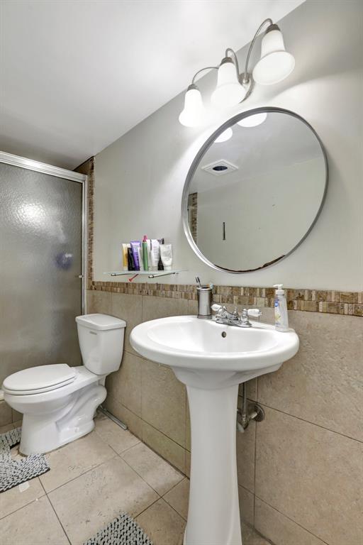 5570 Northwest 44th Street, Unit 518A Tamarac, FL 33319 - Photo 22 of 28 a bathroom with a sink a toilet and mirror