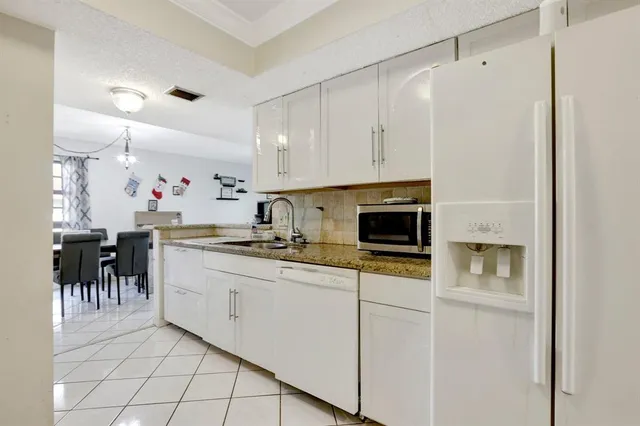 a kitchen with appliances a sink and cabinets