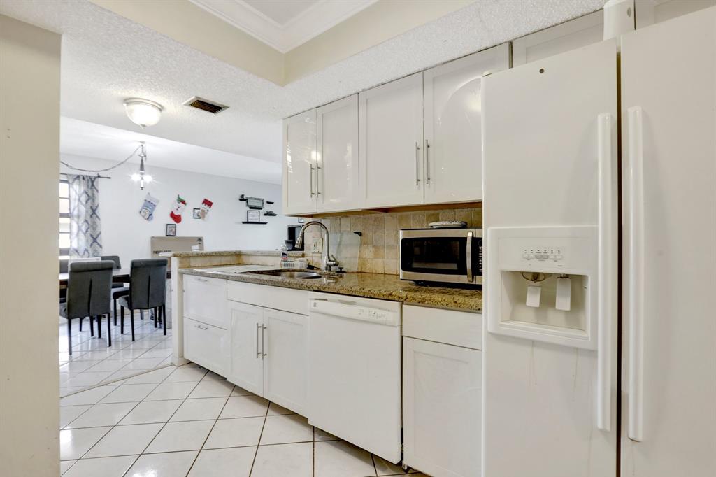 5570 Northwest 44th Street, Unit 518A Tamarac, FL 33319 - Photo 3 of 28 a kitchen with appliances a sink and cabinets