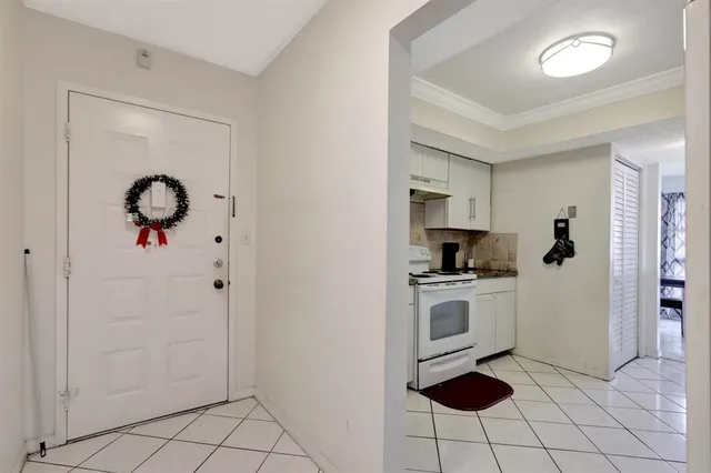 a kitchen with a refrigerator and white cabinets