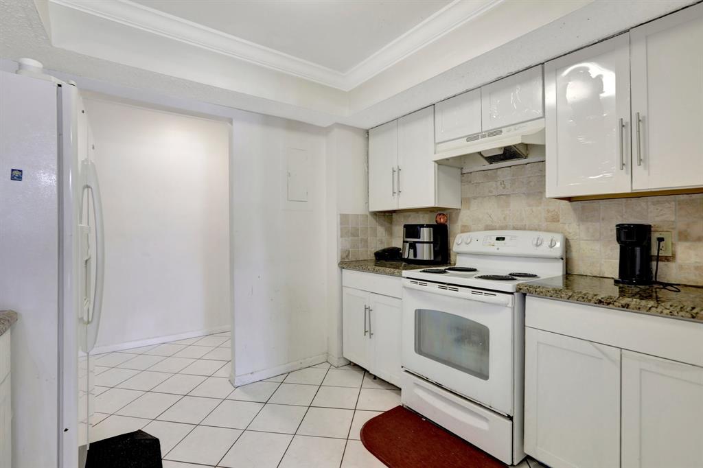 5570 Northwest 44th Street, Unit 518A Tamarac, FL 33319 - Photo 5 of 28 a kitchen with stainless steel appliances granite countertop a sink a stove a microwave and cabinets