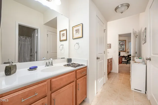 a en suite bathroom with a granite countertop sink and a mirror